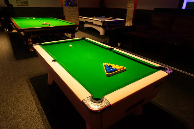 A snooker table under its lamp